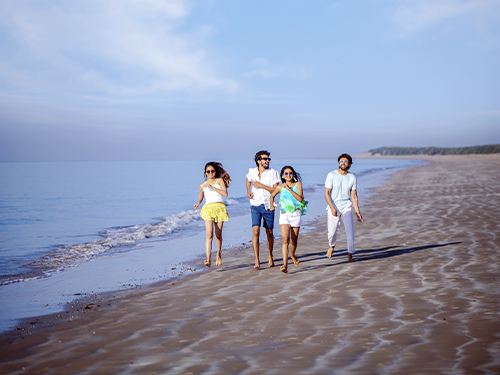 Golden sands and calm waters at Mandvi Beach in Kutch, Gujarat with tourists enjoying camel rides