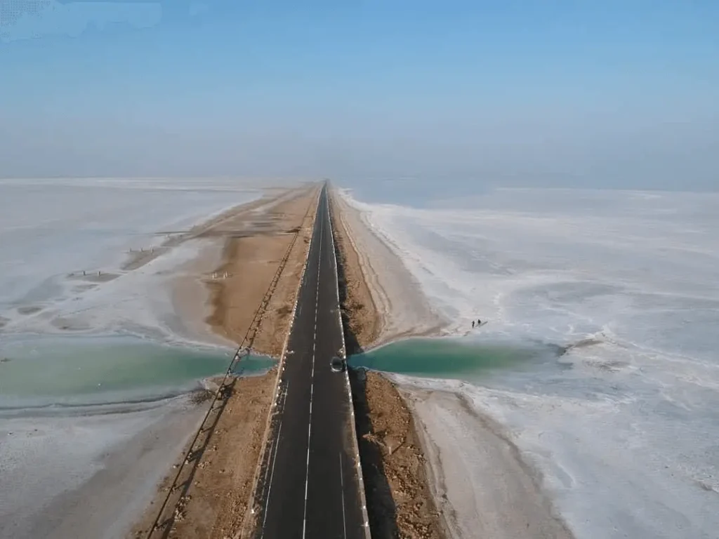 A straight desert road flanked by salt flats known as the Road to Heaven near Dholavira, Kutch